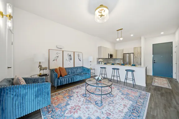 Resident living room with hardwood-style flooring and designer lighting at Webster Station Flats