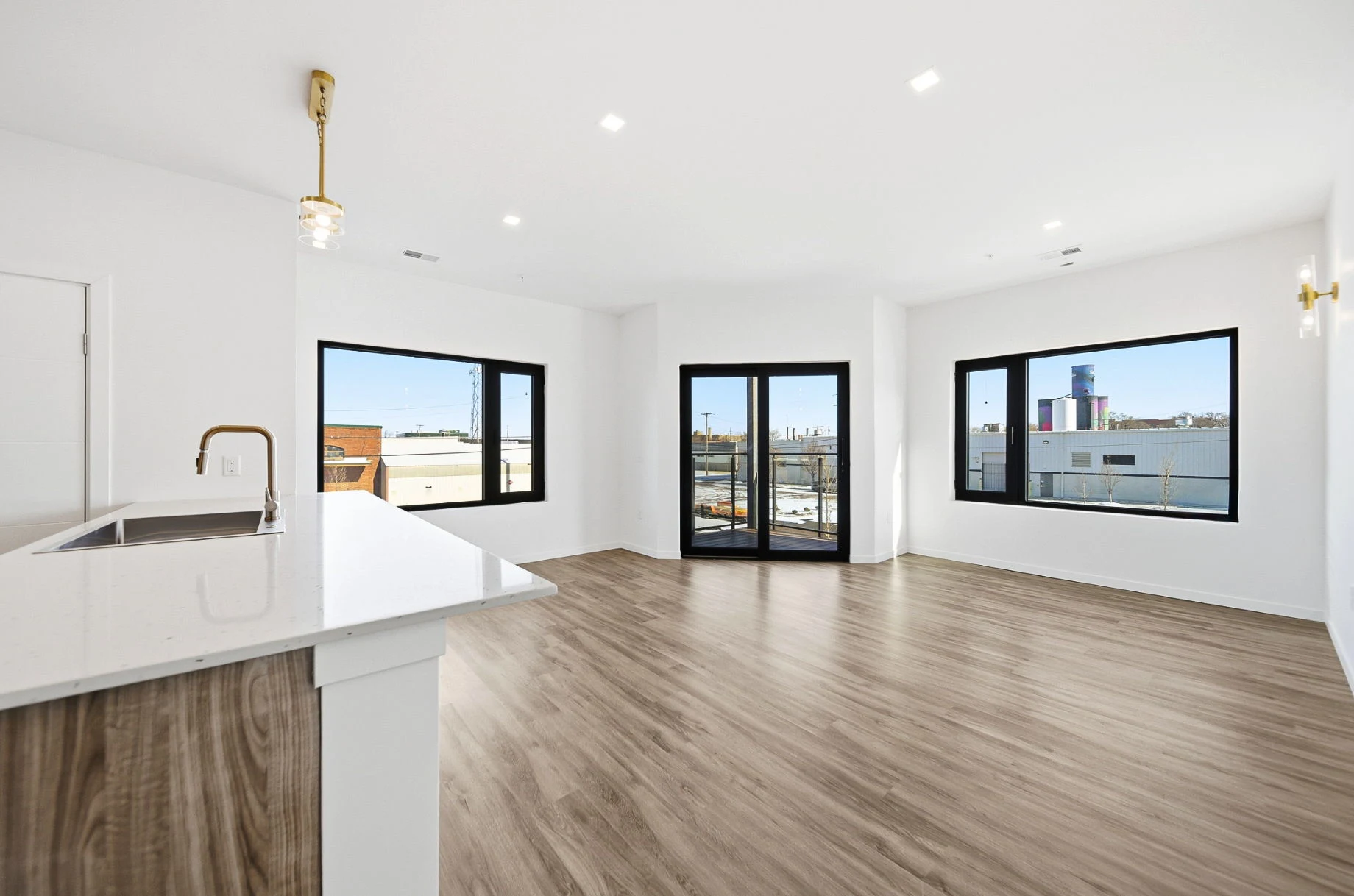 Open-concept living and dining area with a private balcony in a Webster Station Flats apartment in downtown Dayton